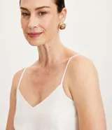 Blusa blanca de viscosa con breteles finos y escote en pico.