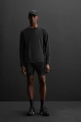 Shorts de running negros con malla interior, cintura elástica ajustable con cordón, bolsillo trasero con cierre, bolsillo multifunción en la malla interior, perneras perforadas, bajo termofijado, aberturas laterales y logo estampado.