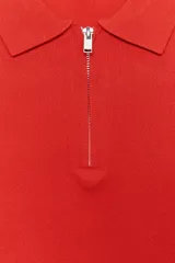 Sweater rojo de punto con cuello polo y cierre frontal con cremallera metálica.