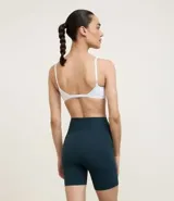 Conjunto deportivo de dos piezas, color fucsia vibrante, compuesto por un top deportivo de escote redondo y una bermuda ciclista de tiro alto.