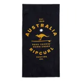 Toalla de playa negra con estampado en color dorado que incluye el logo de Rip Curl, un canguro y la frase "Road Trippin' Down Under".