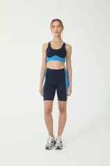 Biker deportivo de cintura alta en azul y azulino, diseñado para ofrecer soporte durante entrenamientos intensos, con costuras en verde y logo BASSET 00's.