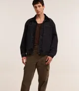 Pantalón baggy color marrón confeccionado en sarga de algodón, con cintura con trabillas, cierre tradicional y bolsillos cargo laterales.
