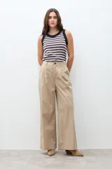 Pantalón de mujer color beige, tiro alto, con pliegues (pinzas) frontales y corte ancho y recto en las piernas.