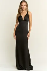 Vestido largo de fiesta negro, corte sirena, con escote profundo en V y espalda descubierta. Confeccionado en tela fluida.