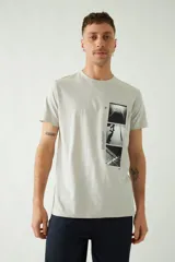 Remera de manga corta color gris claro con cuello redondo y estampado de tres fotos en blanco y negro en el frente.