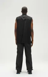 Camisa negra sin mangas de calce oversize con doble bolsillo y detalle de remaches en el frente, confeccionada en tejido twill de alta calidad.