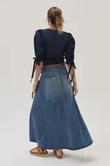 Falda larga de jean celeste con corte evasé, tiro medio y detalles bordados en el frente.