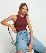 Body color marrón, sin mangas, con cuello halter y cierre en la entrepierna.