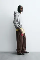 Sudadera gris con capucha ajustable, corte boxy fit, manga larga, bolsillo tipo canguro y estampado en la espalda.