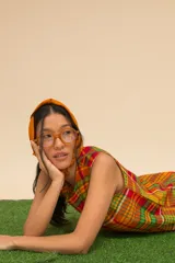 Vestido corto sin mangas con estampado de cuadros en tonos azul, rojo, verde y blanco. Tiene cuello redondo y ruedo con flecos.