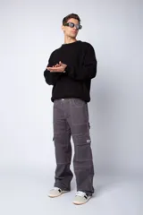 Pantalón cargo negro de corte relaxed fit y tiro medio, con múltiples bolsillos y costuras a contraste en color blanco.