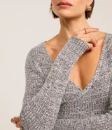 Blusa negra de punto acanalado, con escote en V profundo y mangas largas.