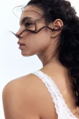 Musculosa blanca de algodón acanalado con breteles finos y escote redondo pronunciado con ribete de encaje.