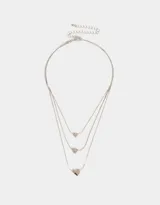 Collar dorado multicadena con tres cadenas de diferentes largos, cada una con un dije de corazón.