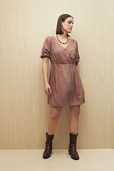 Vestido corto color marrón con estampado de hojas rosas, escote en V, mangas cortas abullonadas con puño elastizado y falda con vuelo.