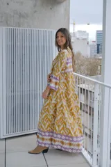 Vestido largo color mostaza con estampado abstracto en blanco, corte holgado, cuello mao y mangas largas con puños elastizados.
