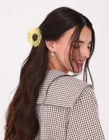Broche para el pelo con forma de margarita amarilla y centro marrón.
