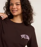 Remera de algodón color marrón con cuello redondo y mangas cortas. Presenta estampa con la frase "Fast Food is my candy" en color rosa.