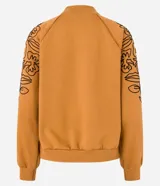 Sweater color ocre con cuello alto y mangas largas con sisas raglán. El sweater tiene bordados de flores en los laterales de las mangas.