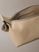 Cartera de hombro Calvin Klein color beige, confeccionada en cuero sintético granulado. Presenta correa ajustable con jacquard con logo, cierre de cremallera en la parte superior, bolsillo interior con ranura para tarjetas y monograma distintivo grabado en la parte delantera.