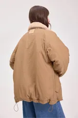 Campera acolchada reversible color verde militar, con capucha y cierre frontal con botones a presión.