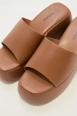 Sandalias negras con plataforma y tira ancha sobre el empeine.