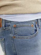 Jean de calce slim fit, color celeste, con cinco bolsillos y cierre con botón.