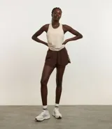 Short deportivo femenino modelo runner, color marrón chocolate con cintura elástica y rayas laterales color crema.
