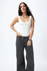 Pantalón jean ancho color gris oscuro, con elástico en la cintura y cordones ajustables en los bajos. Cuenta con grandes bolsillos laterales y traseros.
