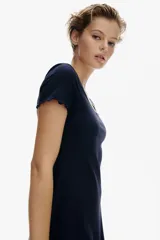 Vestido mini azul marino de manga corta en punto de algodón acanalado con pollera evasé. Modelo con cuerpo entallado y escote redondo amplio con ribete fino en color blanco y moña decorativa de satén. Ribete sobrehilado en mangas y bajo.