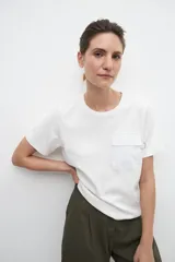 Remera blanca con bolsillo frontal, de manga corta y corte clásico.