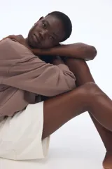 Buzo color marrón topo en tejido liviano de mezcla de algodón. Modelo con cuello redondo y hombros caídos. Remate acanalado en cuello, puños y bajo.