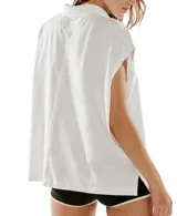 Remera estilo polo blanca de corte amplio con cuello clásico y botonadura corta en el frente. Tiene mangas cortas con dobladillo y aberturas laterales en el ruedo.