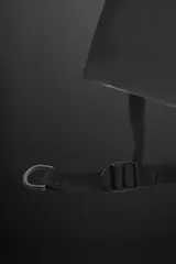Bandolera negra de tejido técnico con correa ajustable, cierre con cremallera y detalle de texto y logo estampados.
