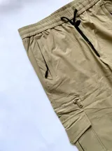 Pantalón cargo color beige con bolsillos laterales y logo de la marca Kaboa en la solapa de uno de los bolsillos.