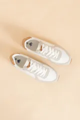 Zapatillas deportivas blancas con detalles en gris y marrón claro.