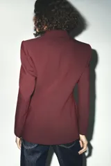 Blazer marrón de corte entallado, con cuello solapa, manga larga, bolsillos delanteros con solapa y cierre frontal con un botón.