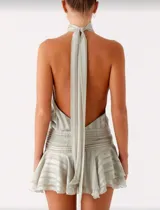 Vestido corto color verde con cuello halter, espalda descubierta, cintura elastizada y falda con volados.