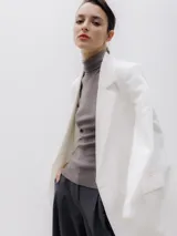 Blazer blanco de corte oversize, con cuello de solapa y cierre con botones.