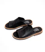 Sandalias bajas de cuero vacuno color negro, con suela de goma y horma de punta redonda. Producto de horma chica, se recomienda pedir un talle más.