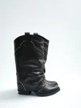 Bota de caña alta color negro, de cuero sintético, con detalles de tachas plateadas.