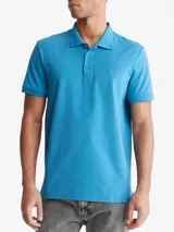 Chomba celeste de manga corta, confeccionada en mezcla de algodón y poliéster. Presenta cuello clásico con solapa de dos botones y logo de Calvin Klein bordado en el pecho.