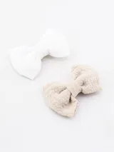 Set de dos broches para el pelo con forma de moña, uno color crudo y otro color beige.