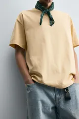 Camiseta color arena de algodón compacto, corte recto, cuello redondo y mangas cortas.