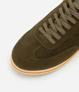 Championes de hombre de estilo retro, color verde oliva, con recortes en gamuza sintética, cierre con cordones y suela de goma con detalles en blanco y naranja.