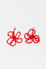 Par de caravanas colgantes con forma de flor, hechas con cuentas rojas facetadas y engarzadas con hilo de nylon. Cierre de gancho plateado.