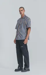 Camisa de manga corta con cuello cubano y estampado a rayas verticales en tonos azul, amarillo y rojo.