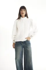 Camisa blanca de estilo romántico con cuello alto, mangas largas abullonadas y detalles de broderie.