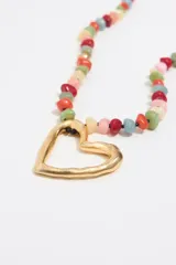 Collar de piedras multicolores con cuentas doradas y colgante de metal dorado en forma de corazón.